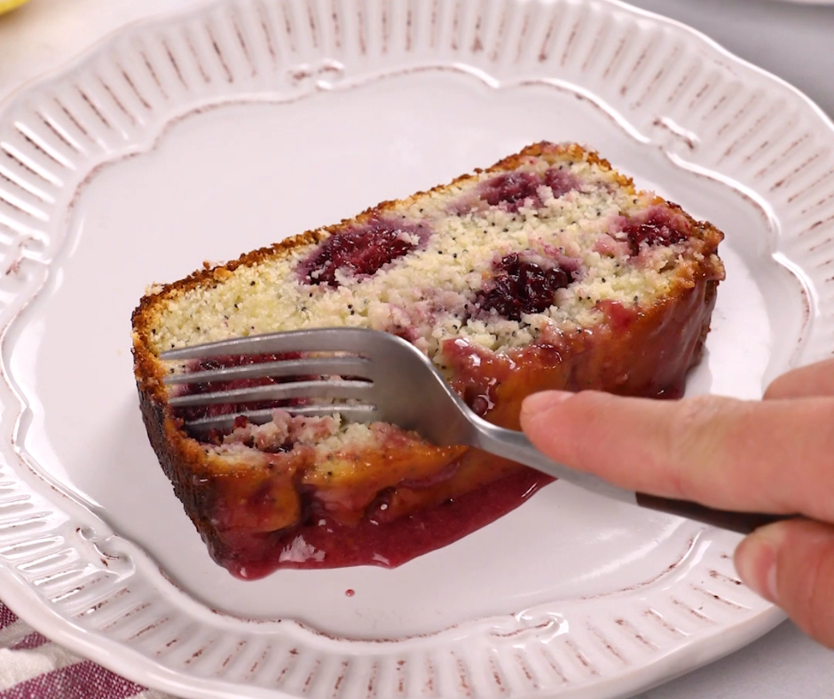 a fork cutting into a slice of blackberry yogurt poppyseed cake