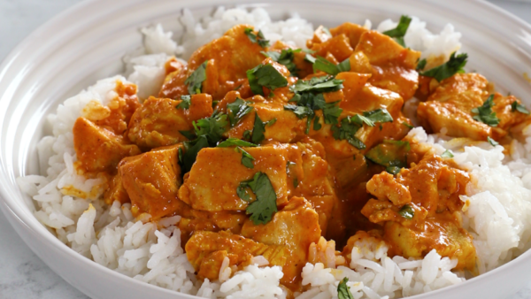 White bowl filled with jasmine rice and chicken tikka masala