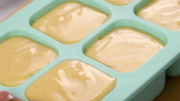 an ice tray filled with cheese sauce