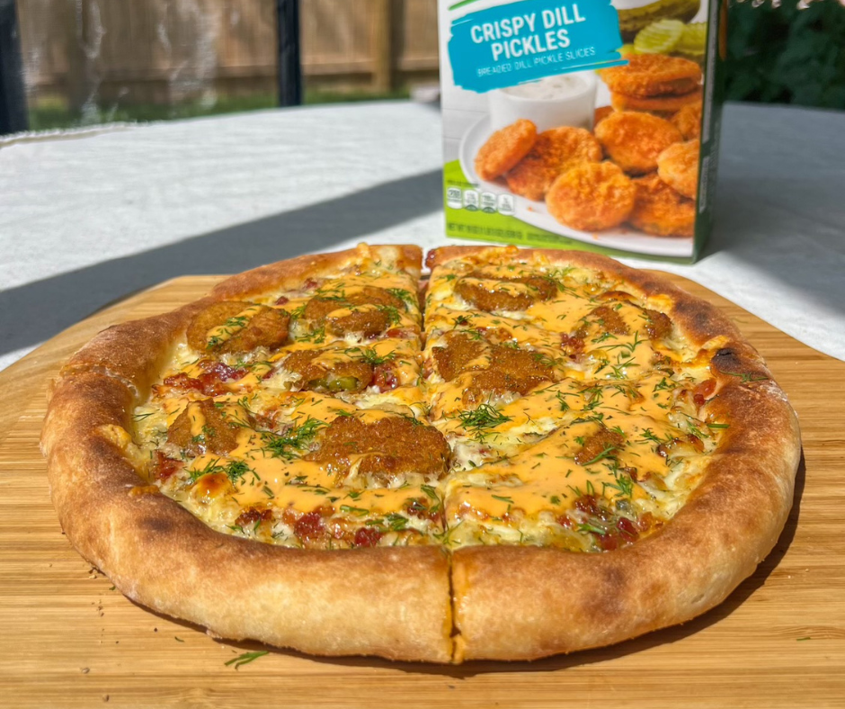 fried pickle pizza on a wooden cutting tray