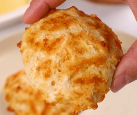 a hand holding a Three-Ingredient Cheesy Yogurt Drop Biscuits Recipe