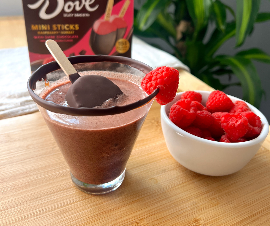 Chocolate Raspberry Martini with a popsicle in it next to a bowl of raspberries