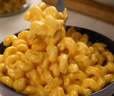 a fork scooping mac and cheese out of a bowl